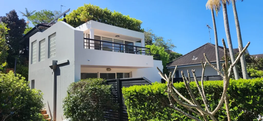 Finished white exterior and dark balcony railings of a painted Mosman house