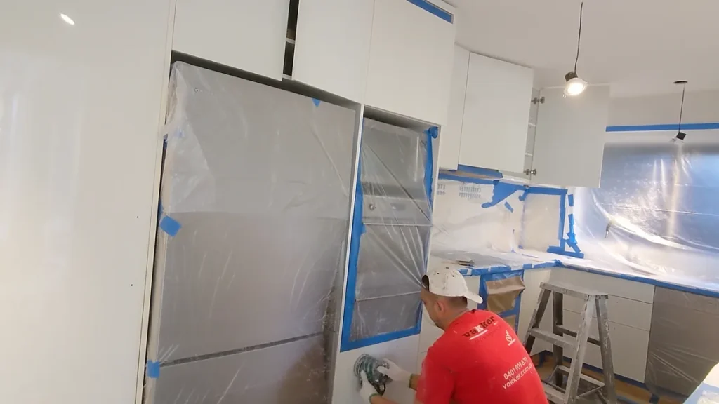 Vakker Australia painter sanding kitchen cabinetry during a house repaint in Mosman
