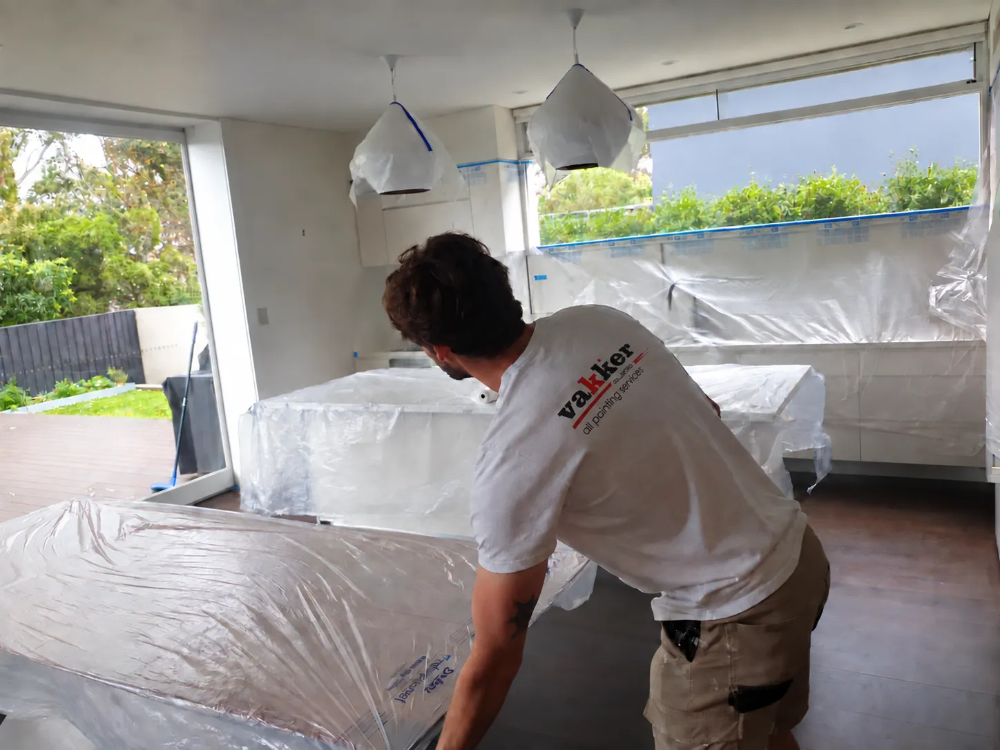 Vakker painter protecting furniture before interior painting in Bondi